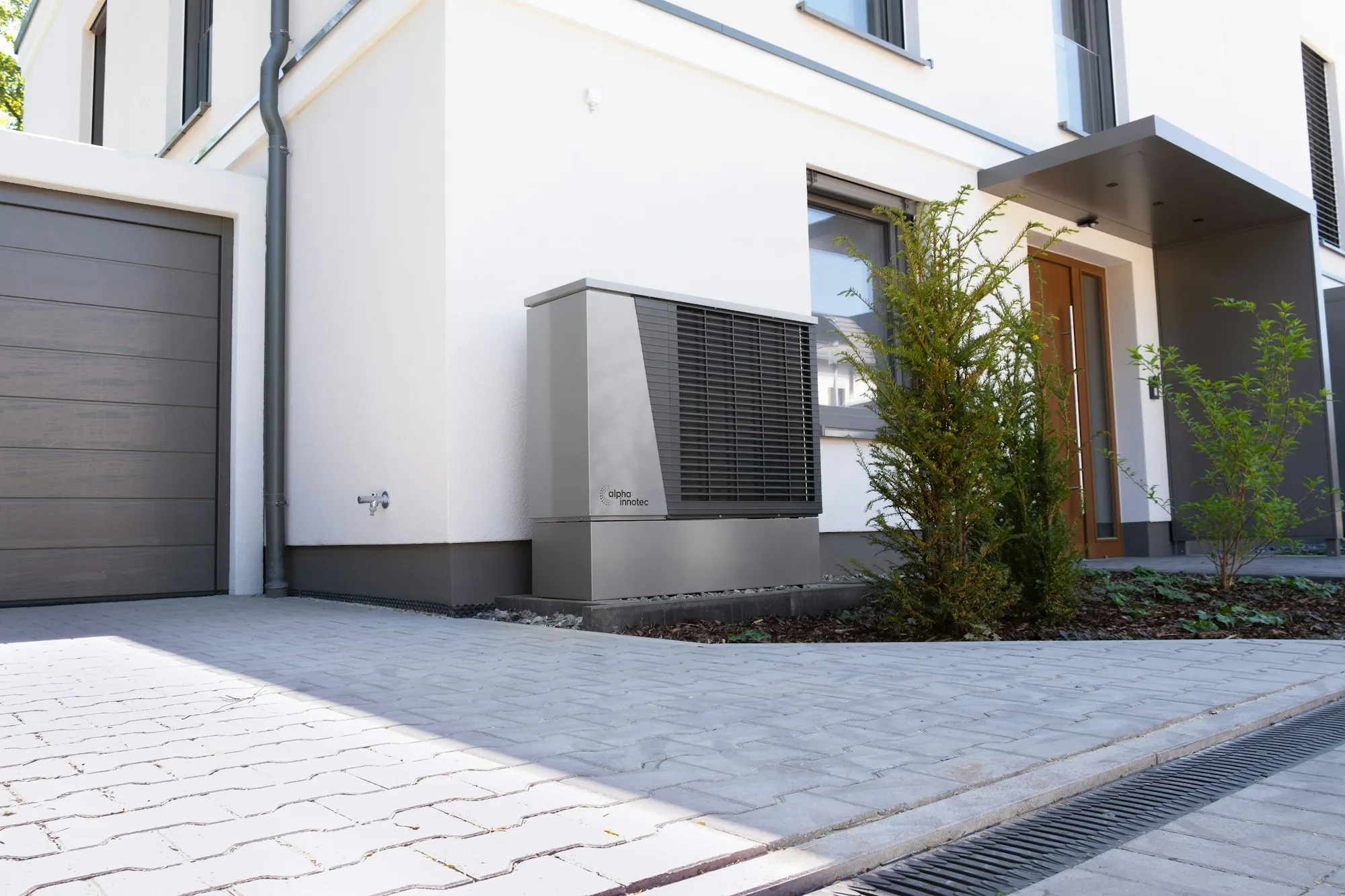 A modern two-story home with a clean driveway and young trees