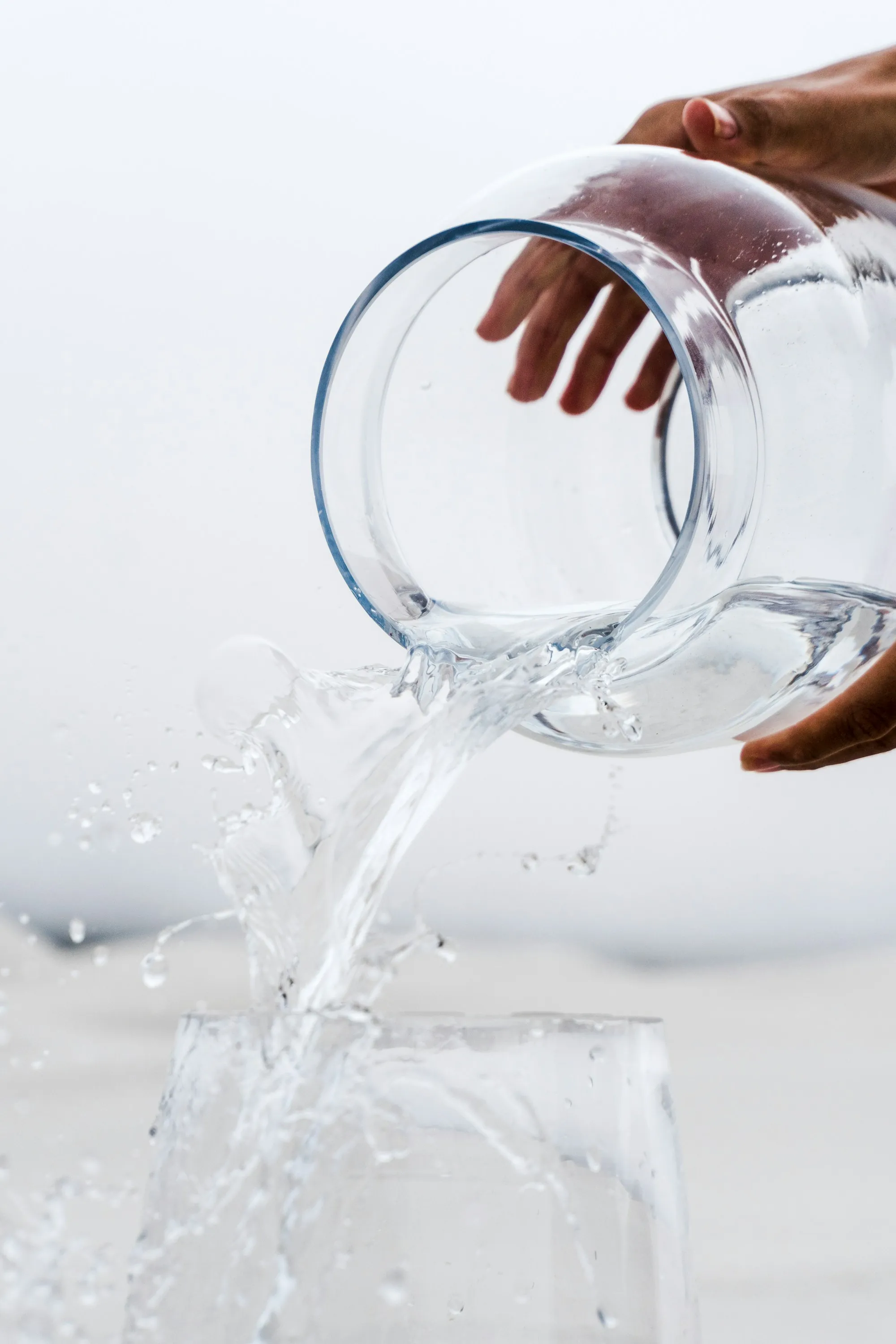 Clear water being poured from a glass pitcher