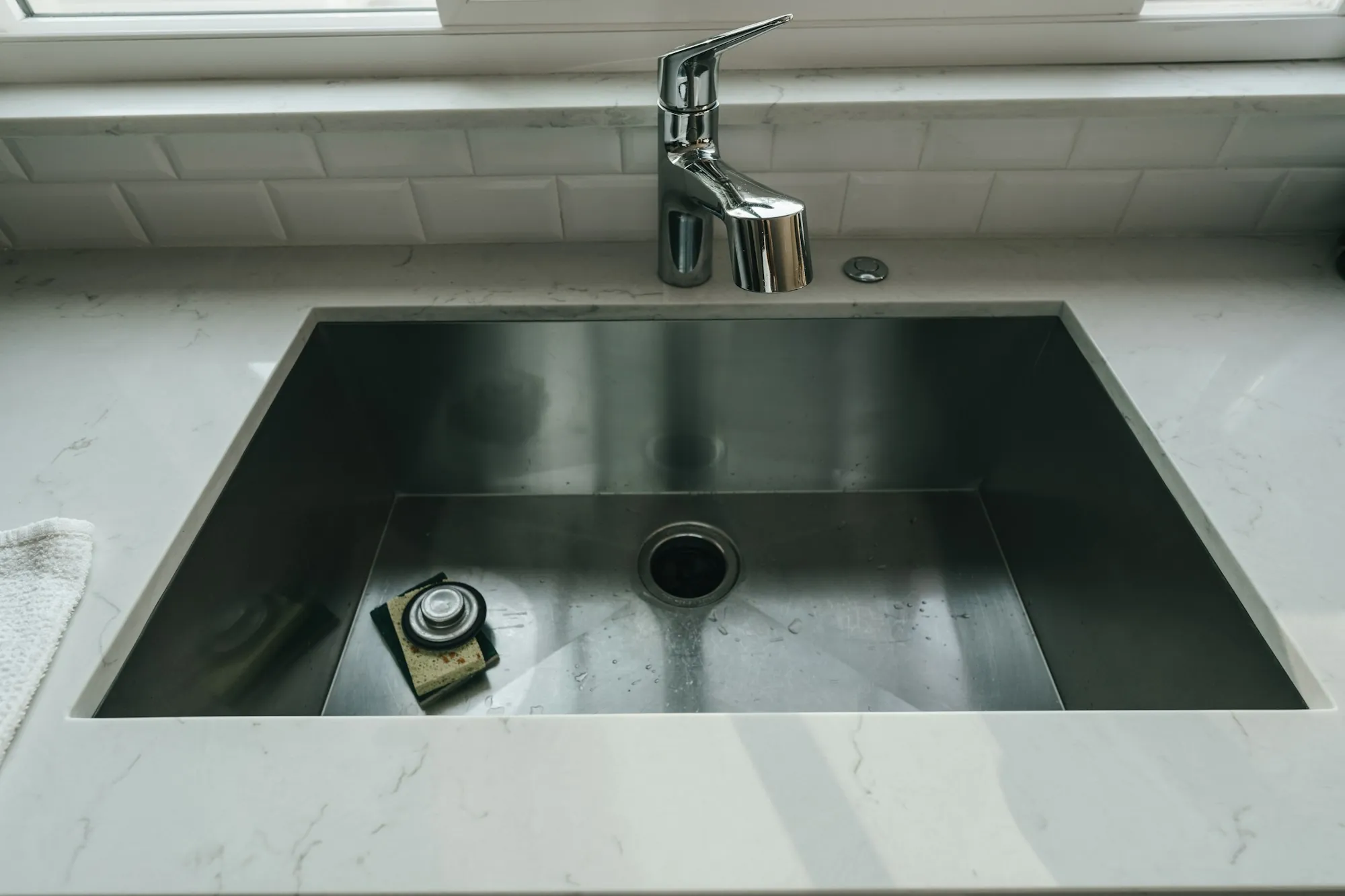 A stainless undermount kitchen sink with a single-lever faucet