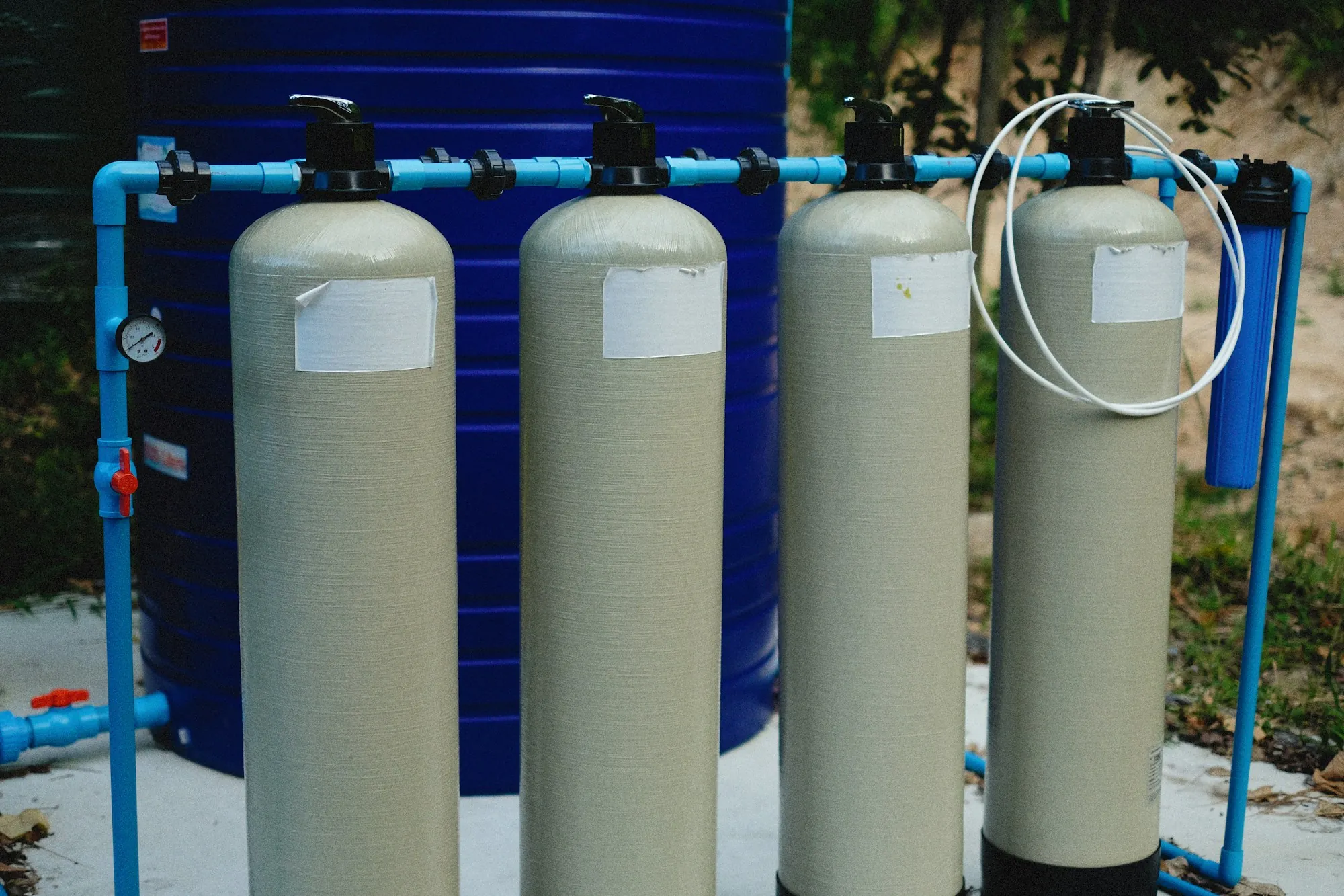 Two tall filtration tanks plumbed into a home's main water line